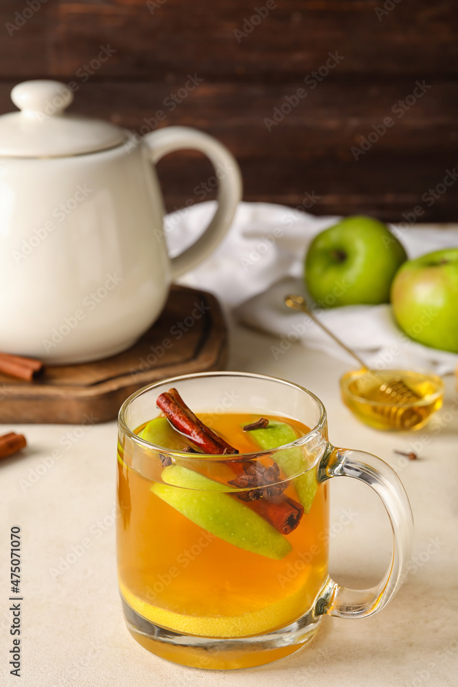Glass cup of tasty fruit tea with cinnamon on white background