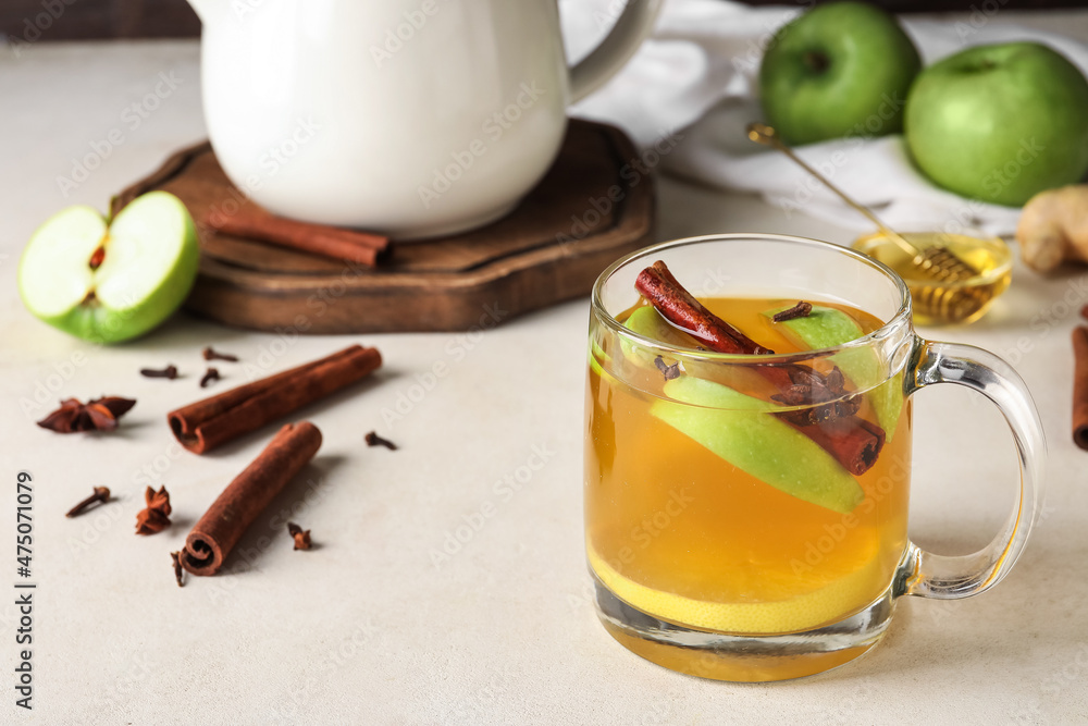 Glass cup of tasty fruit tea with cinnamon on white background