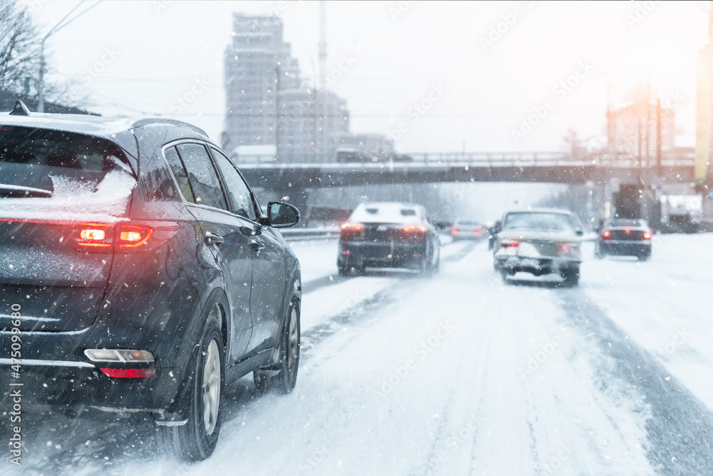 Scenic view snow covered city highway slippery road drive cars moving ...