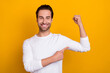 © deagreez - Photo of cheerful positive man direct finger arm showing biceps isolated on yellow color background