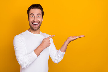 Sticker - Photo of astonished impressed person finger indicate hand palm empty space isolated on yellow color background