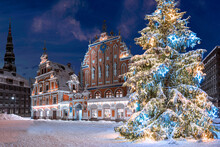 Illuminated Christmas Tree At Night. Town Hall Square With House Of The Blackheads And Christmas Tree In Winter, Old Town Riga, Latvia. Christmas Postcard Of Riga.