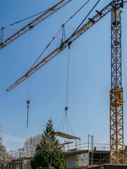 Canvas Print - building crane lifting a pre-fabricated section