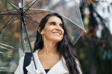 Hispanic Woman Umbrella Near Trees