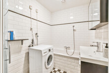 Interior Of Tiled Bathroom With Washing Machine Bathtub And Sink