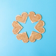 Minimal Flatlay With Brown Heart Shaped Cookies On Bright Blue Background. Star Shaped Copy Space.