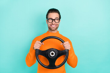 Wall Mural - Portrait of cheerful man hold wheel look interested empty space isolated on teal color background