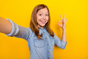 Poster - Photo of impressed small brown hairdo girl do selfie show okey wear denim shirt isolated on bright yellow color background