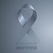 Brain tumor awareness. Gray vector ribbon appears from the the dark background. Modern symbol of fight for volunteers, brain cancer survivors and health care social campaign