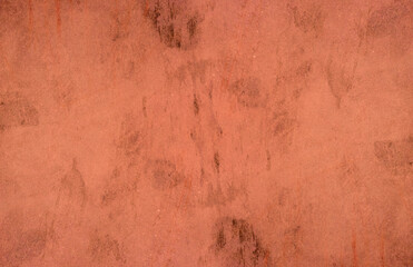 Wall Mural - Red concrete wall surface with scattered black spots for background