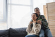 © LIGHTFIELD STUDIOS - teenage african american girl with closed eyes embracing mom sitting on sofa near window