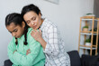 © LIGHTFIELD STUDIOS - african american woman embracing upset teenage daughter standing with crossed arms