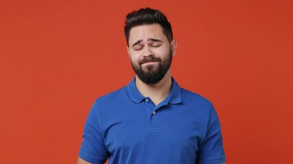 Wall Mural - Confused young bearded brunet man 20s years old wear blue t-shirt look camera pointing fingers himself ask say who me no thanks i do not need it isolated on plain red orange background studio portrait