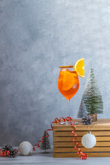 Wall Mural - Italian cocktail aperol spritz in big wine glass with water drops on light Christmas or New Year background