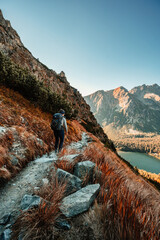 Wall Mural -  Young traveler hiking girl with backpacks. Hiking in mountains. Sunny landscape. Tourist traveler on background view mockup. High tatras , slovakia