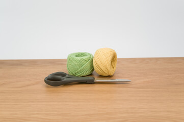 Canvas Print - decorative rustic green yellow yarn ball and scissors on a wooden tabletop