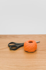 Canvas Print - decorative rustic orange yarn ball and scissors on a wooden tabletop