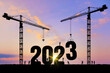 Vector silhouette of construction worker with crane and sky for preparation of welcome 2023 New Year party and change new business. Businessman engineer looking 2023 blueprint in a building site.