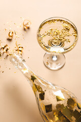 Composition with glass of champagne, bottle and serpentine on color background, closeup