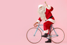 Santa Claus With Christmas Bell And Bicycle On Pink Background