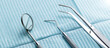 Some dental instruments laying on a blue dental napkin