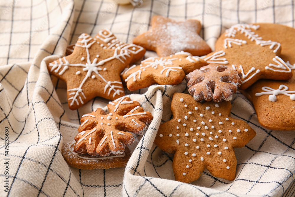 Tasty gingerbread cookies on checkered napkin, closeup