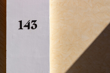 Canvas Print - Closeup of the number 143 on a stone wall