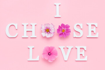 Wall Mural - I choose love. Motivational quote from white letters and beauty natural flowers on pink background. Creative concept Happy Valentine's Day
