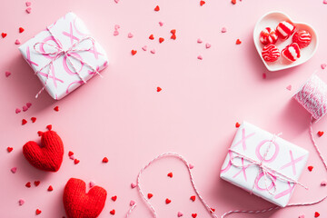 Happy Valentines Day concept. Creative flat lay composition with gift boxes, hearts, ribbon, sweets on pastel pink background. Top view, overhead.