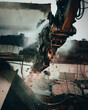Vertical shot of a crane demolishing a building outdoors with a blurry background