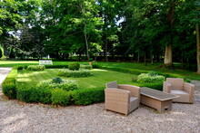 A View Of A Small Recreational Garden In The Middle Of A Public Park With Some Seats And Benches, Shrubs, Great Trees And Paths Seen On A Sunny Summer Day On A Polish Countryside 