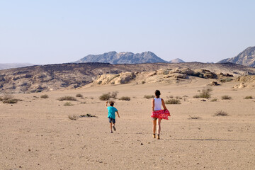Wall Mural - mother and son running through the desert