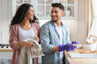 © Prostock-studio - Cheerful Middle Eastern Couple Sharing Domestic Chores, Washing Dishes Together In Kitchen