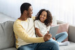 © Prostock-studio - Cute african american father and kid watching cartoons