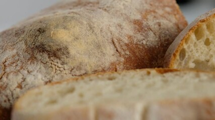 Wall Mural - Camera movement. Top view. Sliced bread lies on a wooden board. Baking bread. Cooking the ciabatta. Italian bread.