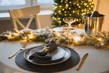 Christmas Elegant Table Setting Decorated Gold Garland, Gray Plate With Napkin Ring. Family Holiday Dinner Ar Home. Close Up.