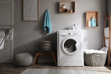 Poster - Laundry room interior with modern washing machine near light wall