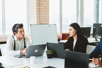 Wall Mural - Group of young business people working and communicating while sitting at the office desk together with colleagues sitting. business meeting