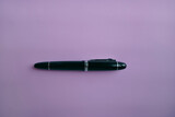 Fototapeta  - close up of a black fountain pen on textured light pink background