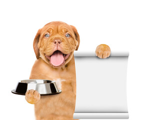 Poster - Happy puppy holds bowl and empty list. isolated on white background