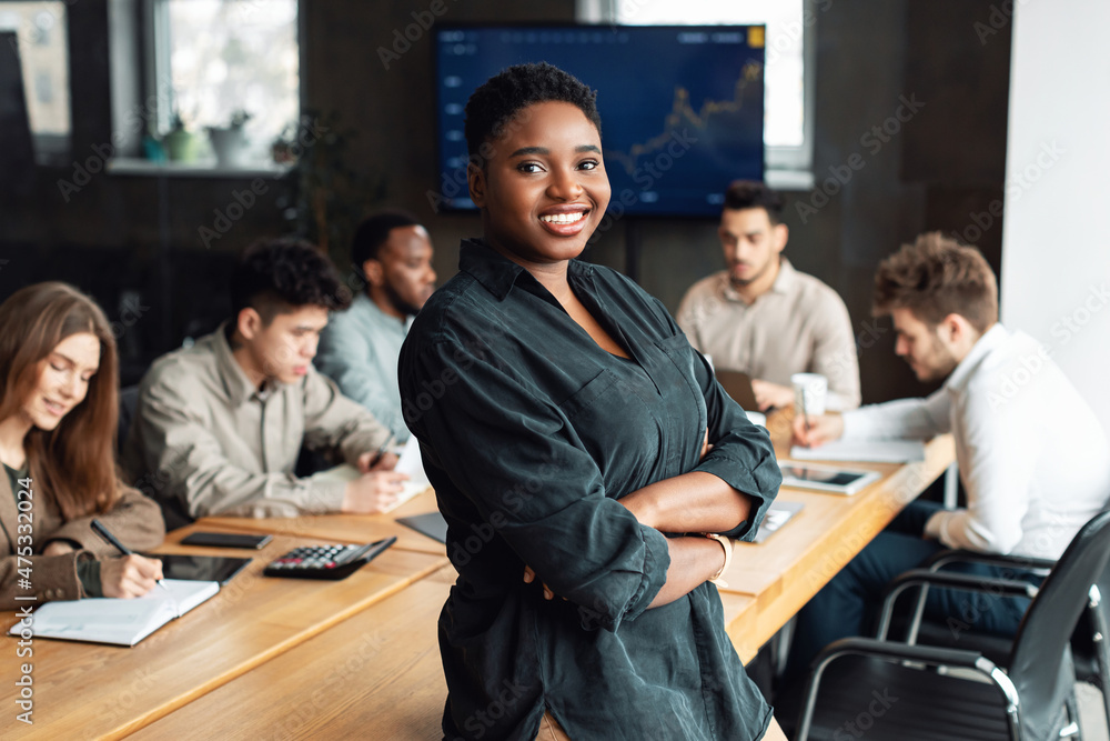 African American businesswoman sitting on desk and posing Stock Photo ...