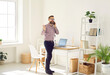 © Studio Romantic - Excited male entrepreneur making business call working remotely from his home office. Man is having active telephone conversation while walking around bright room. Remote business concept.