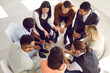 © Studio Romantic - Top view of diverse employees or workers sit in circle talk engaged in teambuilding activity in office. Multiracial people involved in group counseling or session. Teamwork and cooperation.