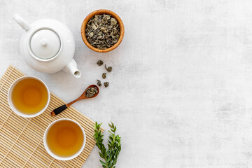 Tea drinking with white teapot and black tea in two cups