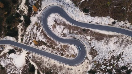 Wall Mural - Aerial drone view on winding mountains road leading to Three peaks of Lavaredo in Tre Cime di Lavaredo National Park in Dolomite Alps. Foggy larches forest around. Autumn in Dolomites, Italy