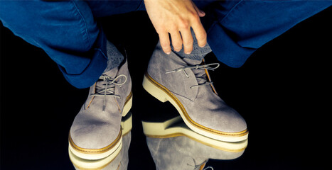 Wall Mural - Male legs wearing gray boots and a reflection of them