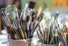 Selection Of Artist's Brushes In Ceramic Containers