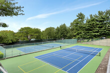 Tennis Courts Surrounded By Green Trees