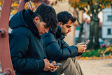 Fototapeta  - young people in autumn with mobile phone in the city