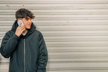 Poster - teenage boy talking on the mobile phone in the street